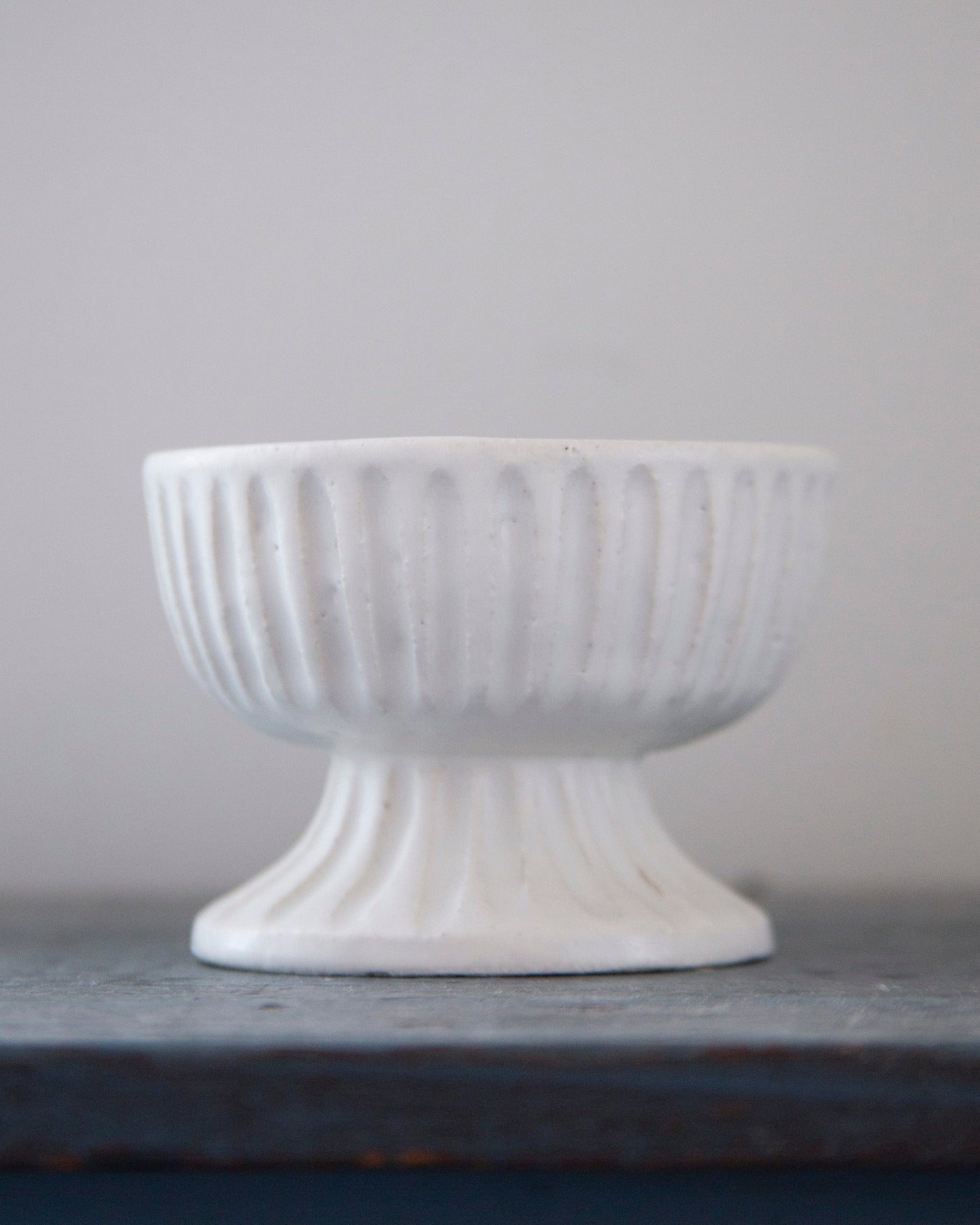 White textured bowl on a gray surface with a light gray background