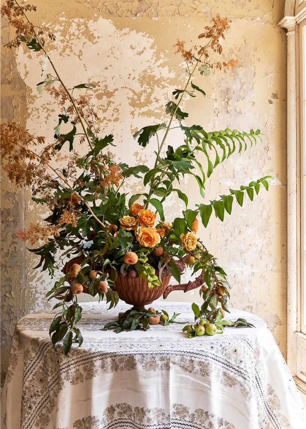 Ariella Chezar and Anne Long Floral Retreat at The Dahlia House in Skagit Valley WA. Floral arrangement in a wooden basket on a table with a textured wall background