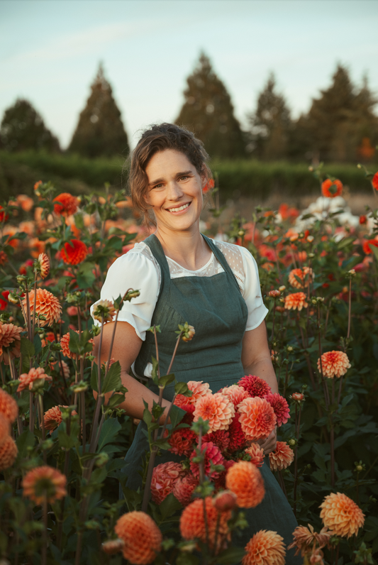 Woman in a field of flowers wearing an apron