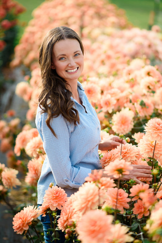 Woman standing among pink flowers in a garden