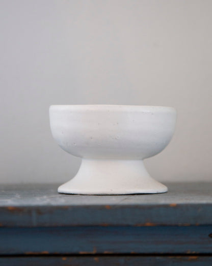 White ceramic bowl on a gray surface with a neutral background