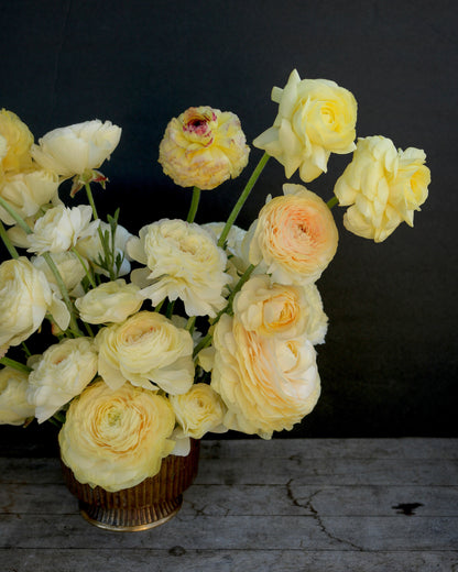 Bouquet of yellow roses in a vase on a dark background
