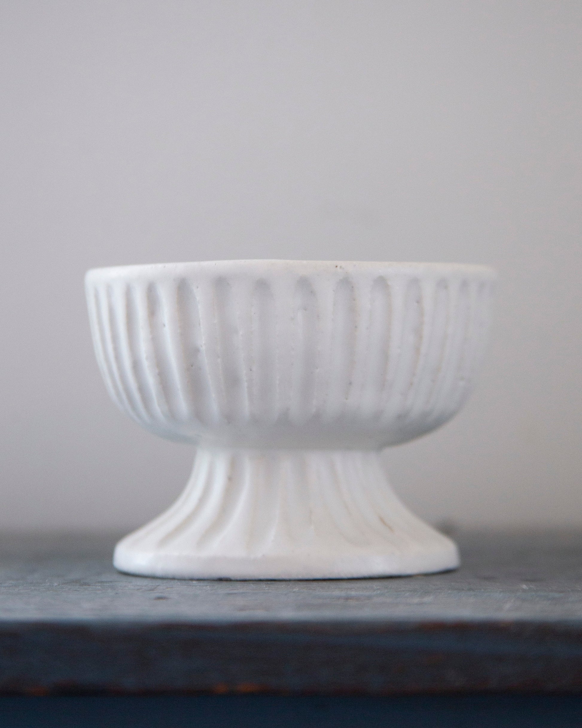 White textured bowl on a gray surface with a light gray background