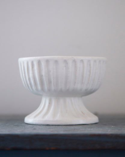 White textured bowl on a gray surface with a light gray background